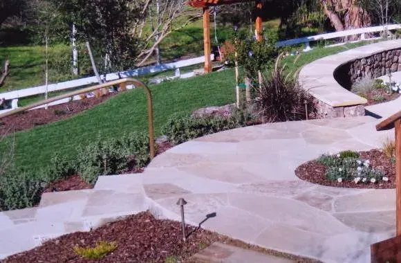 Curved flagstone steps with path lighting and planting beds